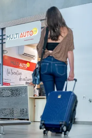 Cliente avec sa valise arrivant au comptoir MultiAuto de l’aéroport Roland Garros à La Réunion